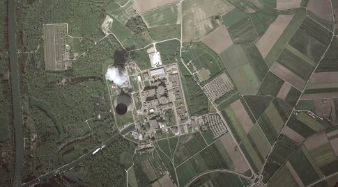 Luftbild eine Kernkraftwerks umgeben von Feldern und Wald.